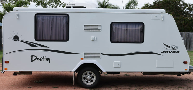 White Jayco caravan with 'Destiny' branding on a dirt road.